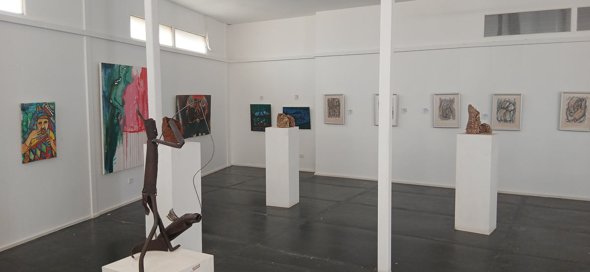 Art gallery with sculptures and paintings on white walls