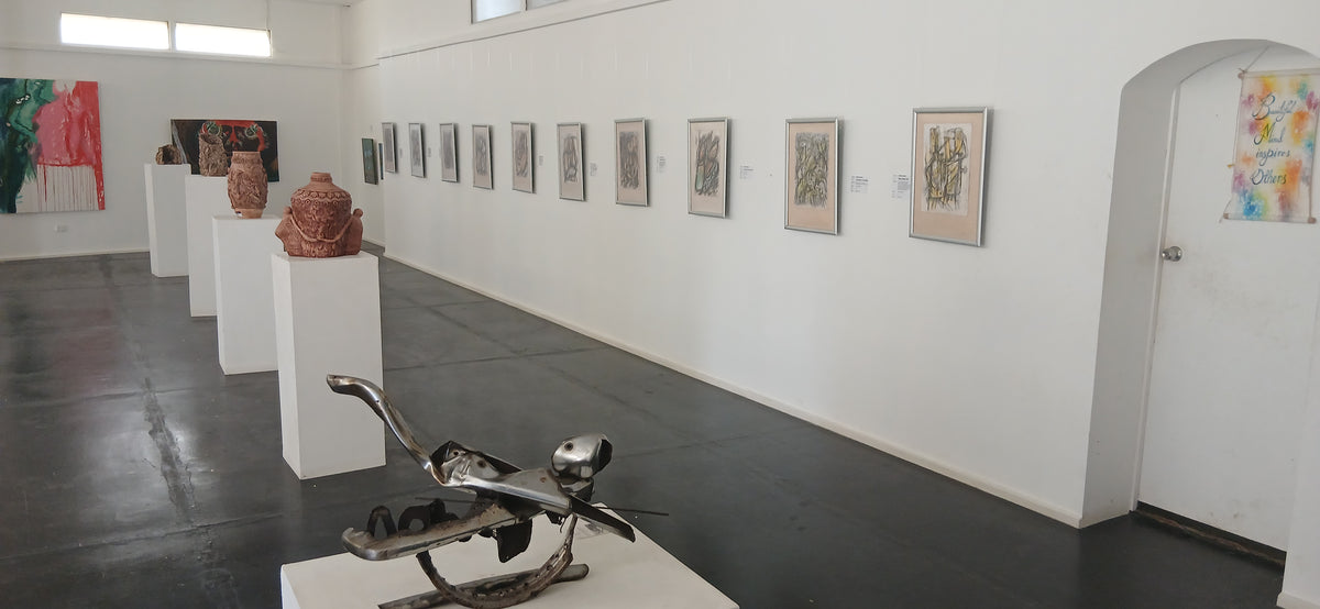 Art gallery with sculptures and paintings on white walls