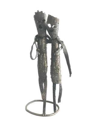 Metallic sculpture of two figures on a stand against a white background